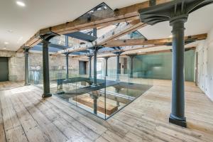 an empty room with glass walls and wood floors at Luxury 2 bed Apartment in historic Royal William Yard in Plymouth