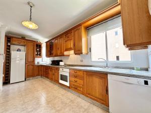 a kitchen with wooden cabinets and a white refrigerator at Radazul Views House in Radazul