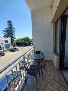 a balcony with a table and chairs and a view of a street at Hotel N in Tskaltubo