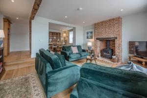 a living room with two green couches and a fireplace at Quay View in Woodbridge
