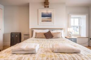 a bedroom with a large bed with two windows at Quay View in Woodbridge