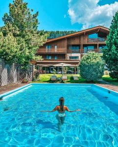 a woman in the water in a swimming pool at Boutique Hotel Planlim in Ortisei