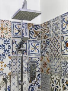 y baño con ducha y azulejos azules y blancos. en B&B La Limonaia, en Tollo