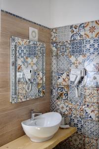 baño con lavabo y azulejos en la pared en B&B La Limonaia, en Tollo