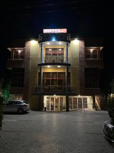 a building with a sign on top of it at night at Edisem Hotel in Tirana