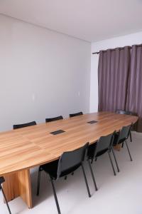 a conference room with a wooden table and chairs at Hotel Borges in Quirinópolis