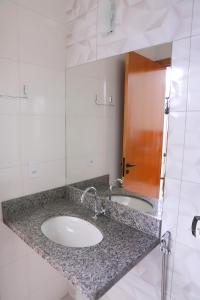 a bathroom with two sinks and a mirror at Hotel Borges in Quirinópolis