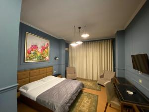a bedroom with a bed and a desk and a tv at Edisem Hotel in Tirana