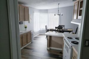 uma cozinha com pisos em madeira e uma bancada branca em Country Quiet em Sanford