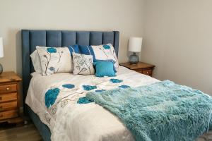 a bed with a blue headboard and a blanket on it at Country Quiet in Sanford