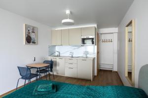 a small kitchen with a table and chairs in a room at Nauji apartamentai su šildomu baseinu, sporto sale, vaikų kambariu, work zona in Palanga