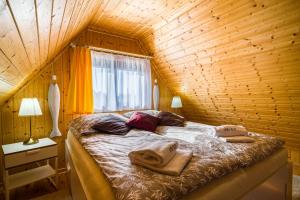 a bedroom with a bed in a wooden cabin at Domek przy morzu in Gąski