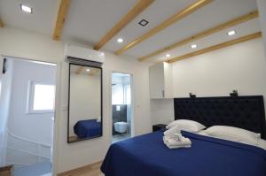 een slaapkamer met een blauw bed en een spiegel bij K rooms old town self check in in Zadar