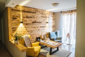 un soggiorno con parete in legno, tavolo e sedie. di Wellness Hotel Ristorante Baita Cerato 