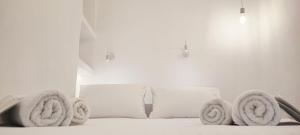 a white bed with towels on top of it at Cozy Now in Tinos Town