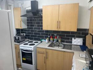 a kitchen with a sink and a stove at Two bedroom flat in London near the 02 in London