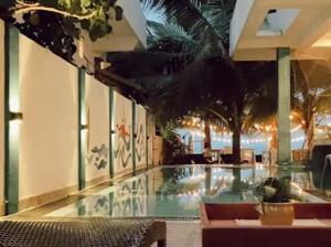 a large swimming pool in a hotel with palm trees at The Bay in Arugam Bay