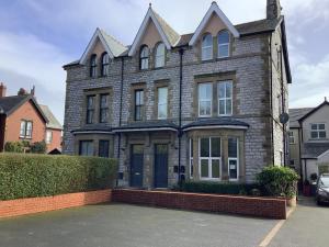 a brick house with a car parked in front of it at Jeffersons Abbey Road Serviced Apartments in Barrow in Furness