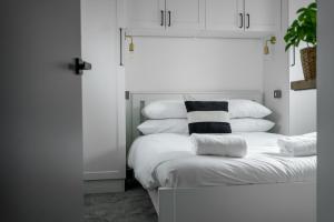 - une chambre avec un lit blanc et des oreillers dans l'établissement Goodstay Lodges by Urban Space, à Barry