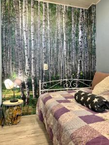 a bedroom with a bed with a mural of aspen trees at Roggendorf in Mechernich