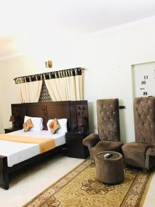 une chambre avec un lit, une chaise et un canapé dans l'établissement Family lodges, à Islamabad