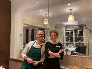 a man and woman posing for a picture in a restaurant at Landhaus Heidekrug in Hildesheim