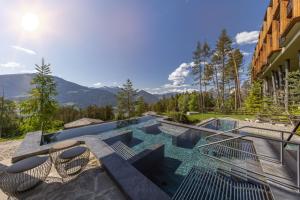 a house with a swimming pool with mountains in the background at My Arbor - Plose Wellness Hotel in Bressanone