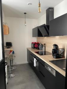 a kitchen with black cabinets and a counter top at Zoralin in Concarneau