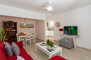 a living room with a red couch and a tv at 2BR Terrace Home - 10 min walk to the Beach in Playa Honda