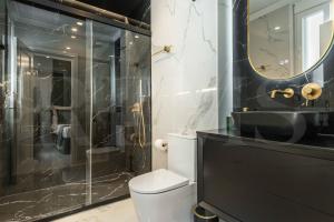 a bathroom with a toilet and a glass shower at NEW Deluxe Apartment - Historic Center by REMS in Málaga