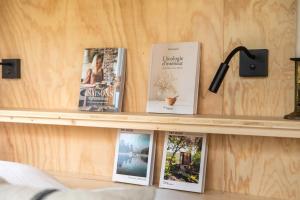 a shelf with books on it in a room at Pépiite Terre de Provence - Lodge nature & spa in Châteaurenard