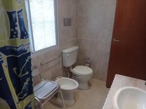 a bathroom with a toilet and a sink and a window at Departamento Independiente Quitilipi in San Salvador de Jujuy