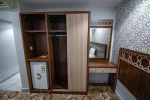 Camera con armadio in legno e frigorifero. di فندق سرايا المسك Saraya Al Misk Hotel a La Mecca