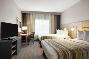クラークスビルにあるCountry Inn & Suites by Radisson, Clarksville, TNのベッド2台と薄型テレビ付きのホテルの部屋