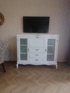Biała szafka z telewizorem na górze w obiekcie Gandrališkės apartamentai w Kłajpedzie