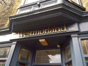 um sinal na frente de uma estalagem de Westmorland em The Westmorland Inn em Bowness-on-Windermere
