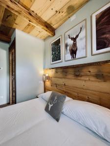 a bedroom with a bed with a deer on the wall at La Maison - Il Riparo del Cervo in Bardonecchia