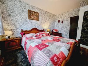 1 dormitorio con 1 cama con edredón rojo y blanco en Mon repos bien merite, en Eppe-Sauvage