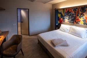 um quarto com uma cama, uma cadeira e um quadro em Il Vigneto em Roddi
