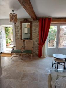 - un salon avec un rideau rouge et une table dans l'établissement Le Logis des Remparts Coeur de la Cité médiévale, à Carcassonne