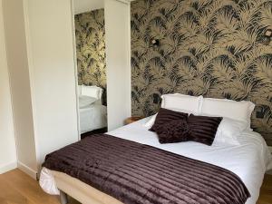 1 dormitorio con 1 cama grande y pared en Zoralin, en Concarneau