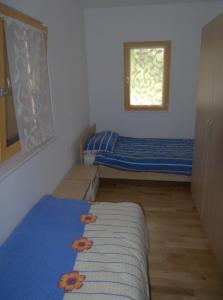 a small bedroom with two beds and a window at Apartment House Cviter in Bovec