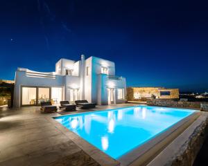 a large swimming pool in front of a house at night at Villa Agavi - Private Pool & Security included - Ideal for events in Mikonos