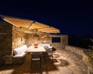 a table and chairs on a stone patio at night at Villa Agavi - Private Pool & Security included - Ideal for events in Mikonos
