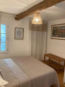 a bedroom with a bed and a chandelier at Le Logis des Remparts à l'intérieur de la Cité médiévale, Jardin privé, Parking inclus in Carcassonne