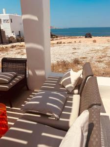 a porch with a bed and a view of the beach at Naousa Home with full sea views in Naousa