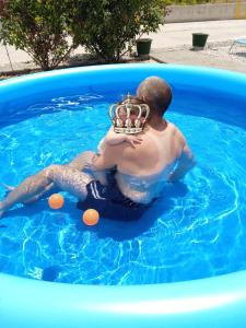 a man wearing a crown in a swimming pool at Denise Villa in Platánion