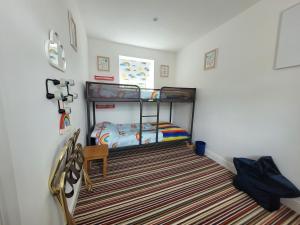 a room with two bunk beds and a striped carpet at Caudle Cottage, Ruardean in Lydbrook