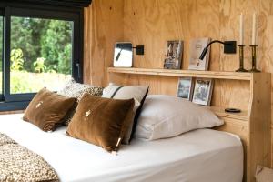 a bedroom with a bed with pillows and a window at L'Atelier Tiny House Provence in Châteaurenard