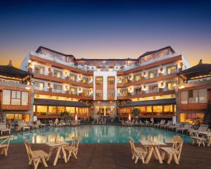 a hotel with a pool and tables and chairs at Chateau Eden El Rouh & Spa in Oualidia